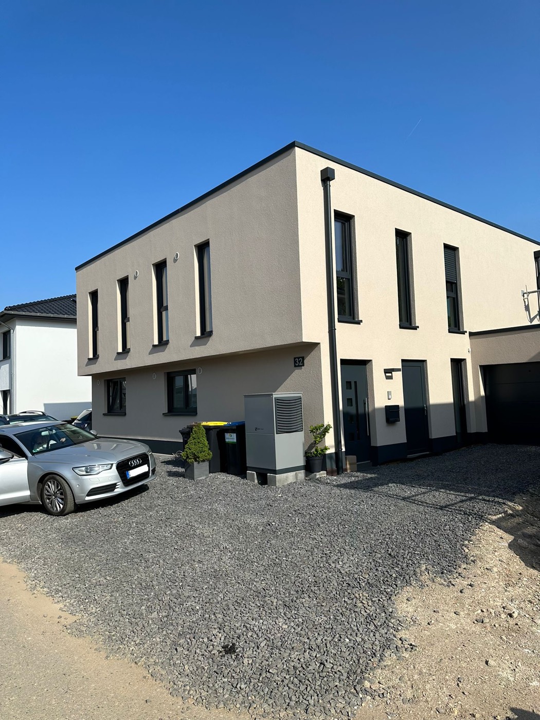 Fertiges zweigeschossiges Haus mit Flachdach und anthrazitfarbenen Fenstern